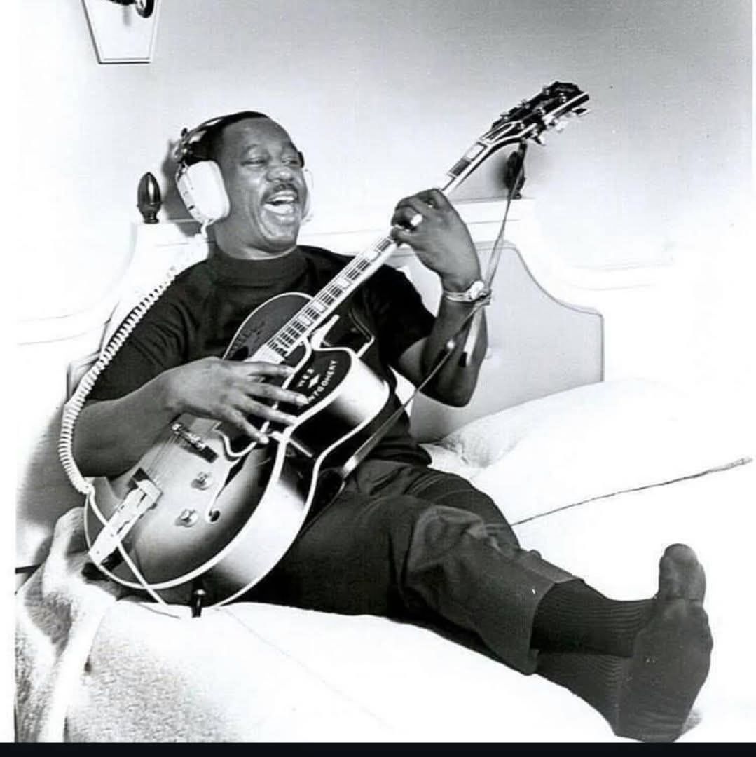Wes atop bed with guitar and phones-wes-headphones-jpg
